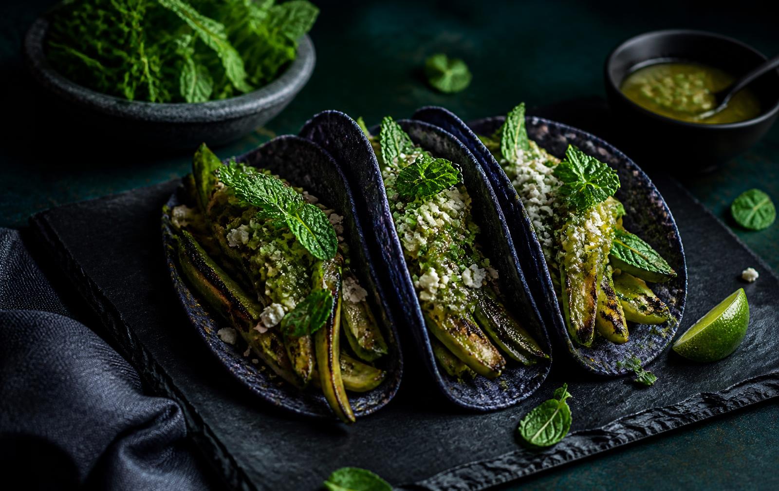 Charred nopal tacos on blue corn tortillas over dark slate
